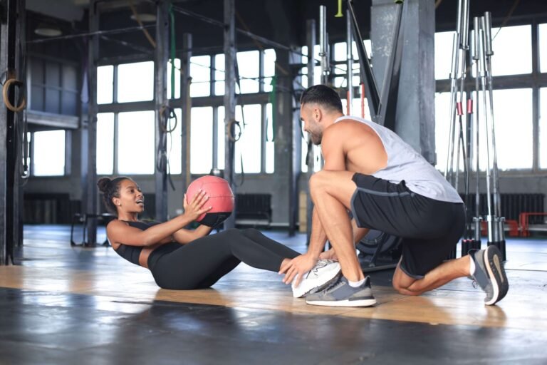 Een man en een vrouw trainen met een bal in de sportschool en vinden hun partner.